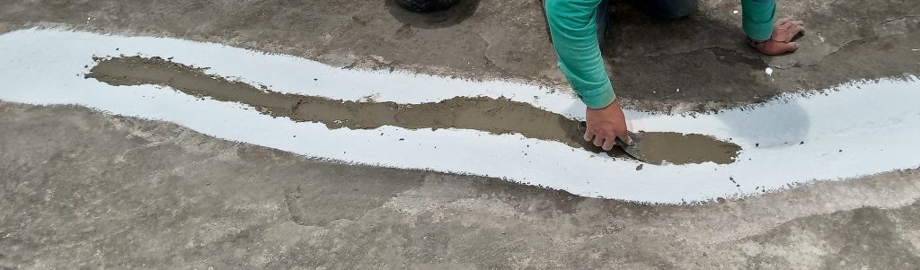 Aplicación de mortero de reparación sobre una fisura en el concreto